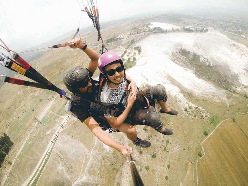 een persoon paragliden met een instructeur boven Pamukkale, Turkije