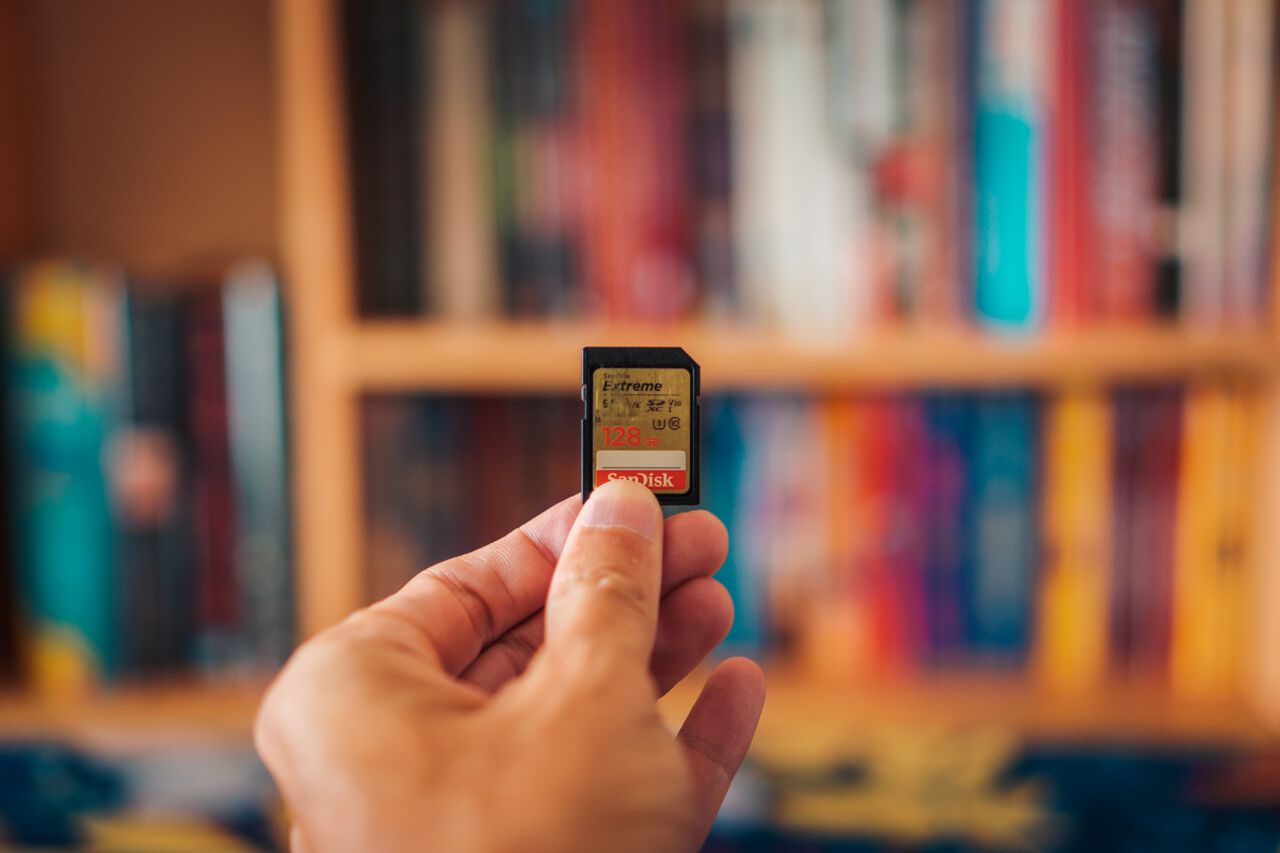 A man holding a 128GB SD Card