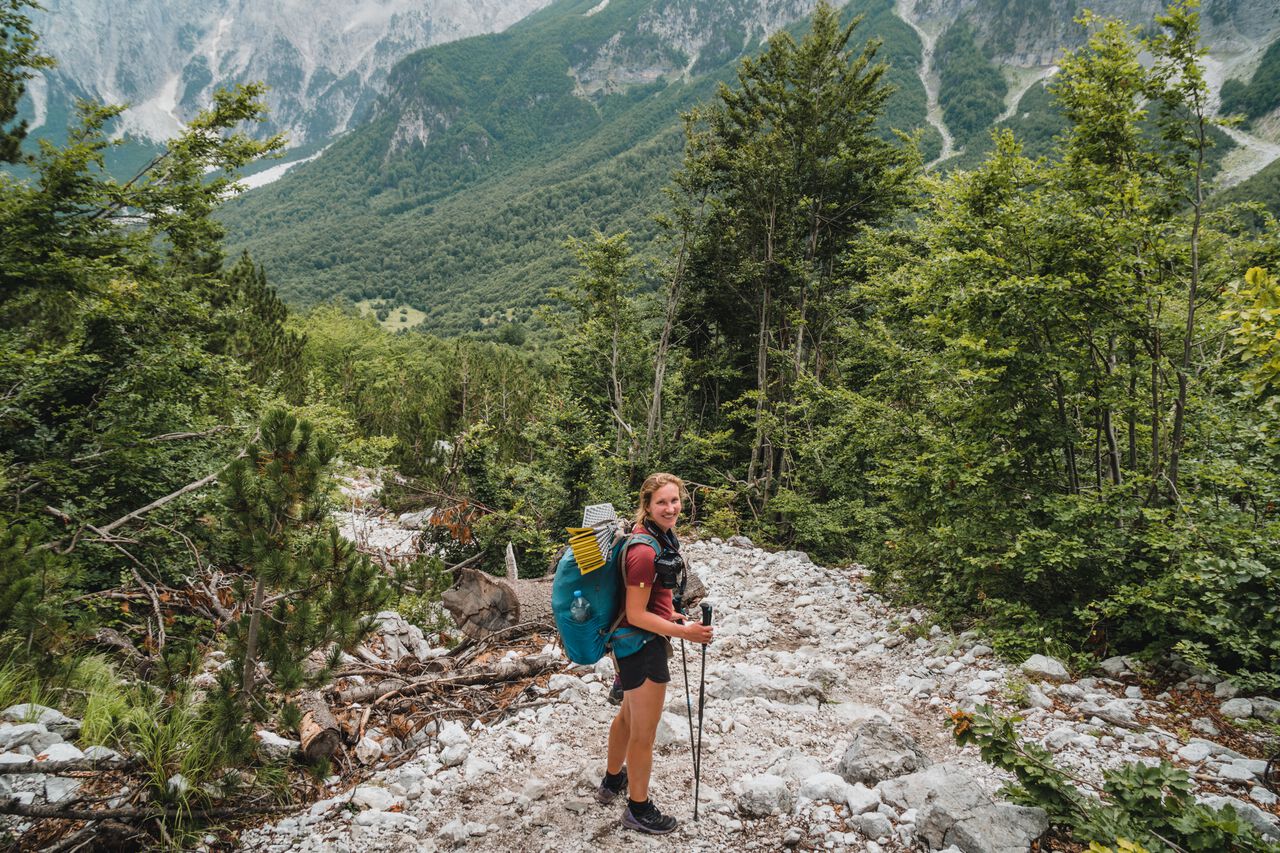 A woman wearing hiking clothes while hiking the Albanian Alps in Europe