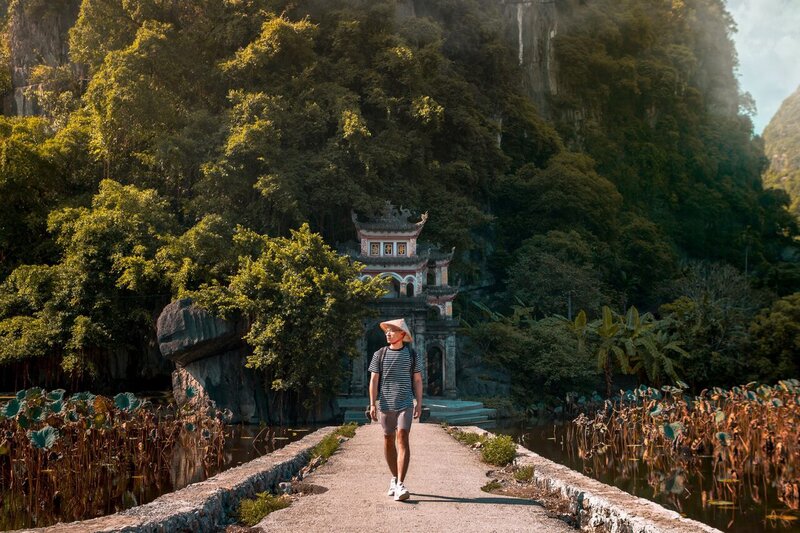 A person walking away from Bich Dong Pagoda Gate in Ninh Binh