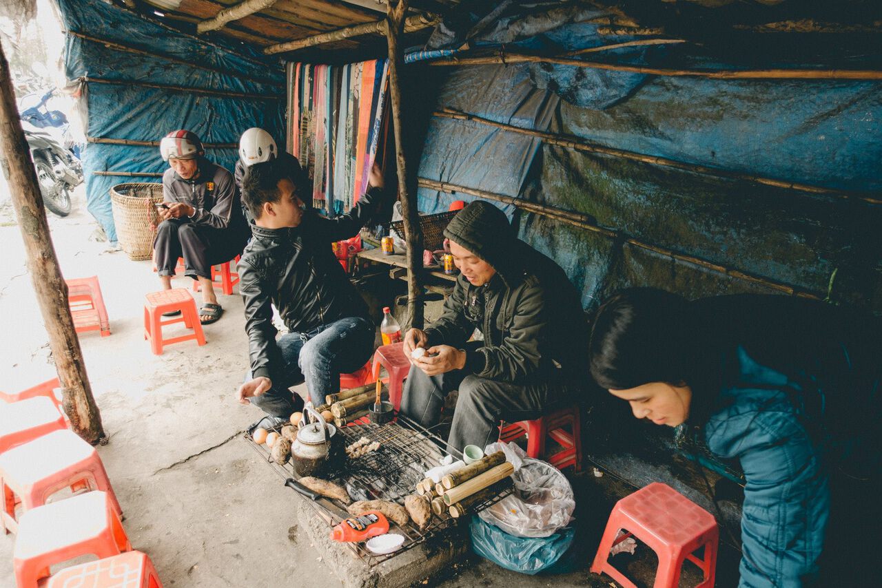 People sitting on a stool eating Vietnamese street food in Sapa