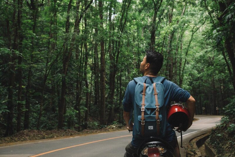 osoba z kaskiem w ręku jeździ motocyklem na Filipinach