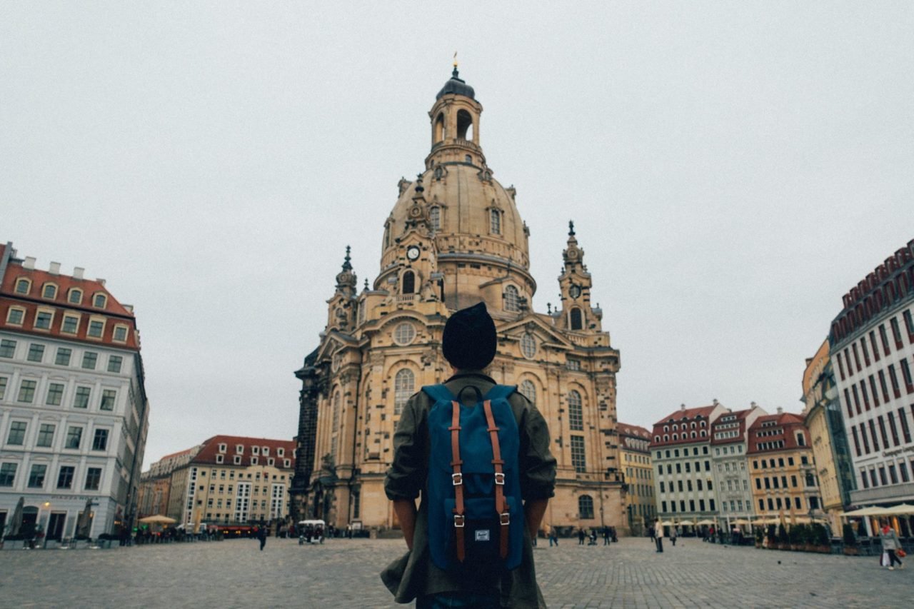 A person carrying a backpack looking at the Dresden Cathedral in Dresden, Germany