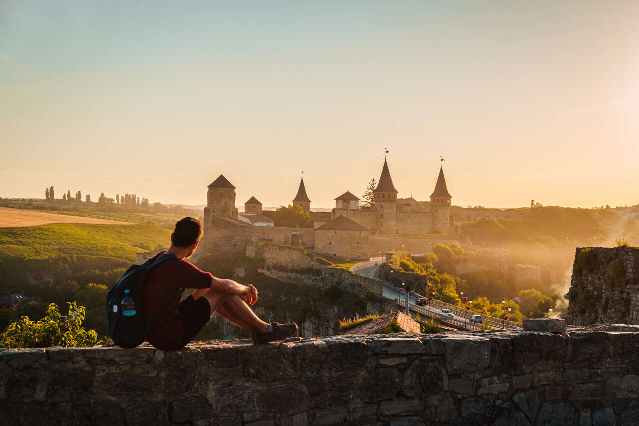 Me watching the sunset behind the castle from a stone wall at Kamianets-Podilskyi, Ukraine