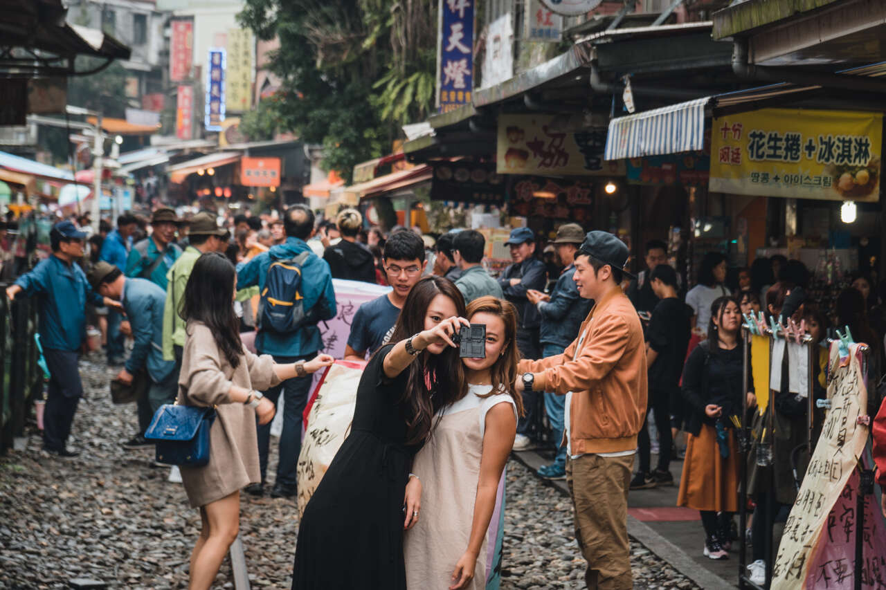 People taking selfies on the train tracks of Shifen, Taiwan.