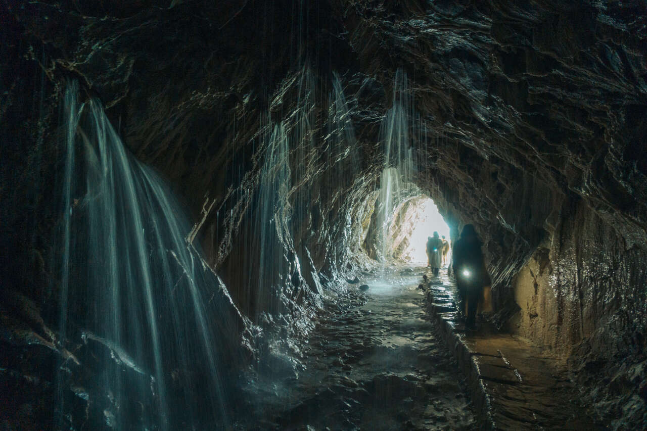 A person with a torchlight walking through the Water Curtain Cave in Taroko National Park, Taiwan.