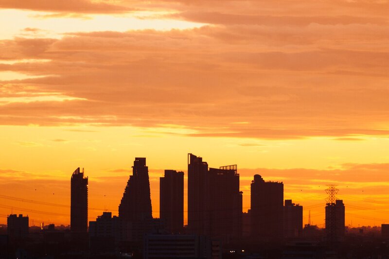 un peisaj urban din Bangkok, în fața cer portocaliu în timpul apus de soare