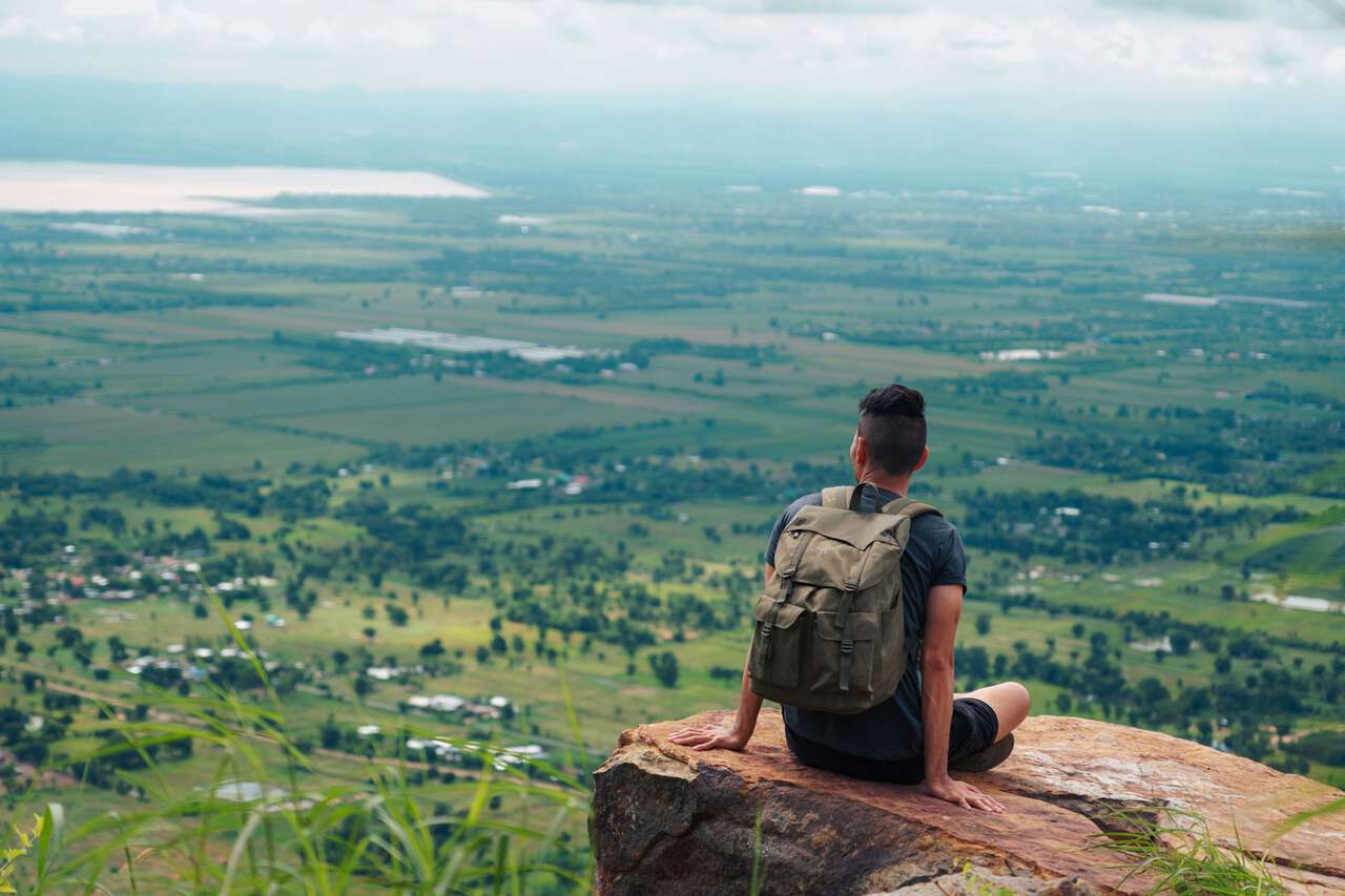 A traveler sitting by the ledge at Khao Phraya Doenthong Viewpoint in Lopburi