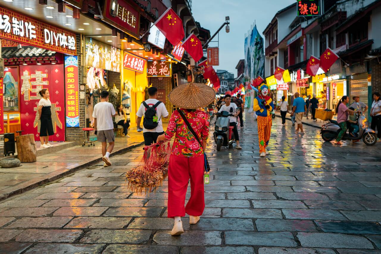 A local merchant walking at Yangshuo West Street at night