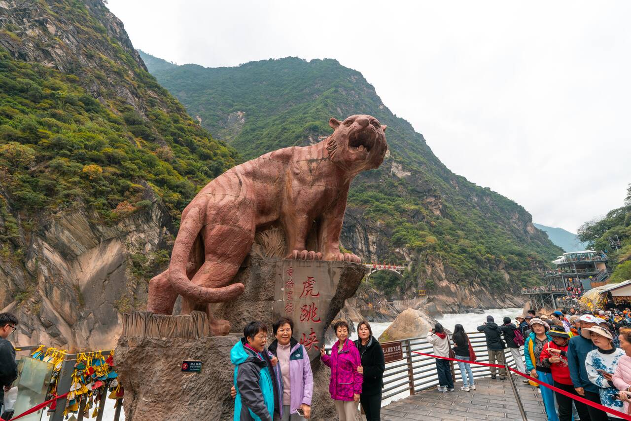 Locals posing at Tiger statue at Tiger Leaping Gorge