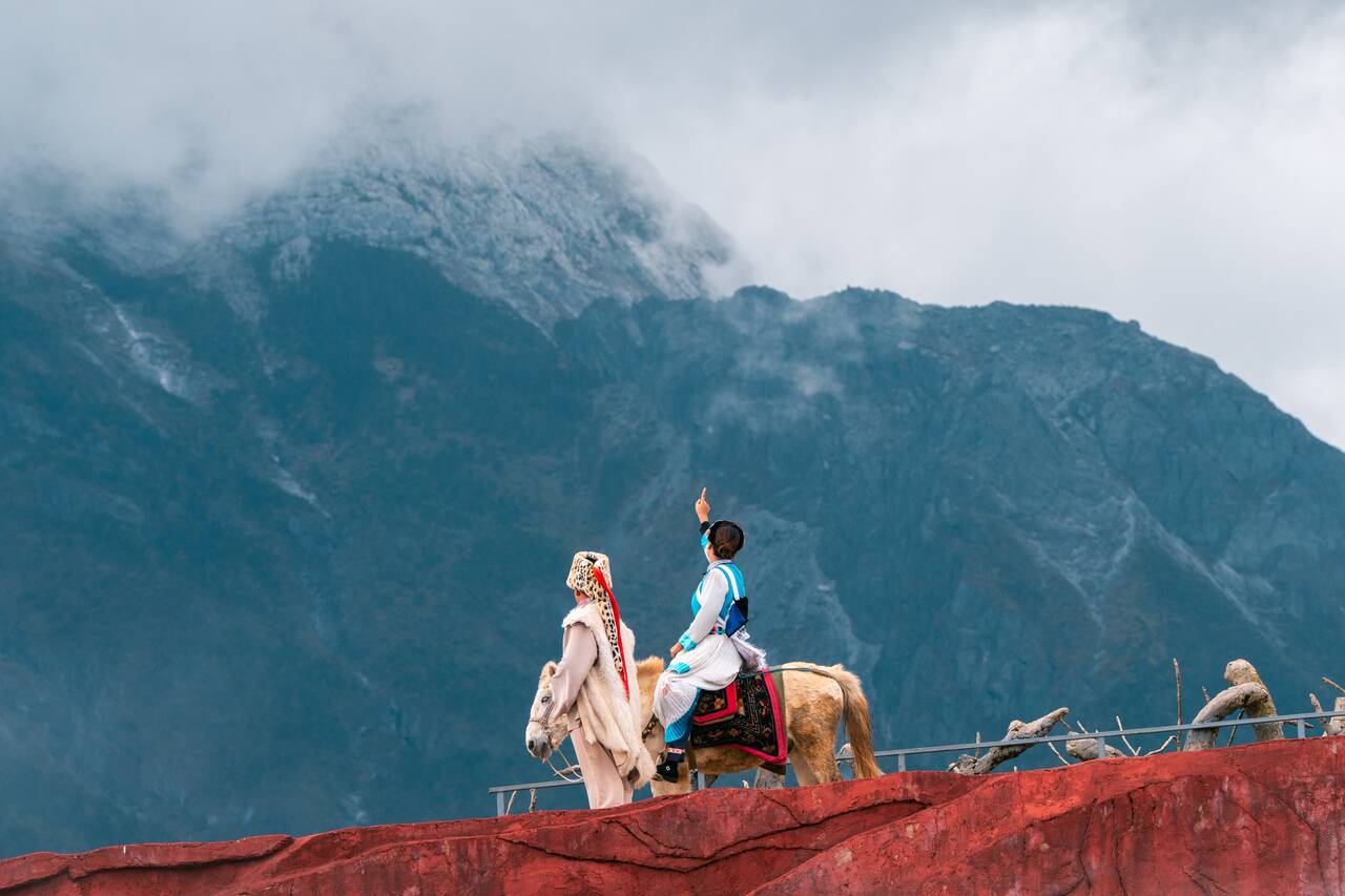 A performer pointing at the mountain at Impression Lijiang Performance