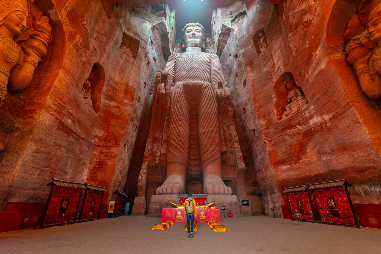 Me standing in front of a massive standing buddha image at Oriental Buddha Park