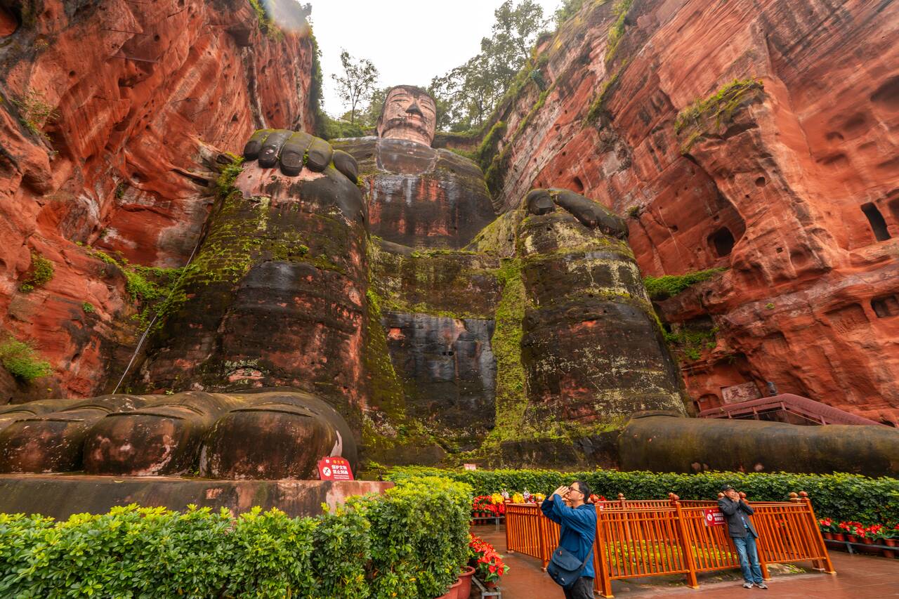 A person praying at the foot of Giant Leshan Buddha