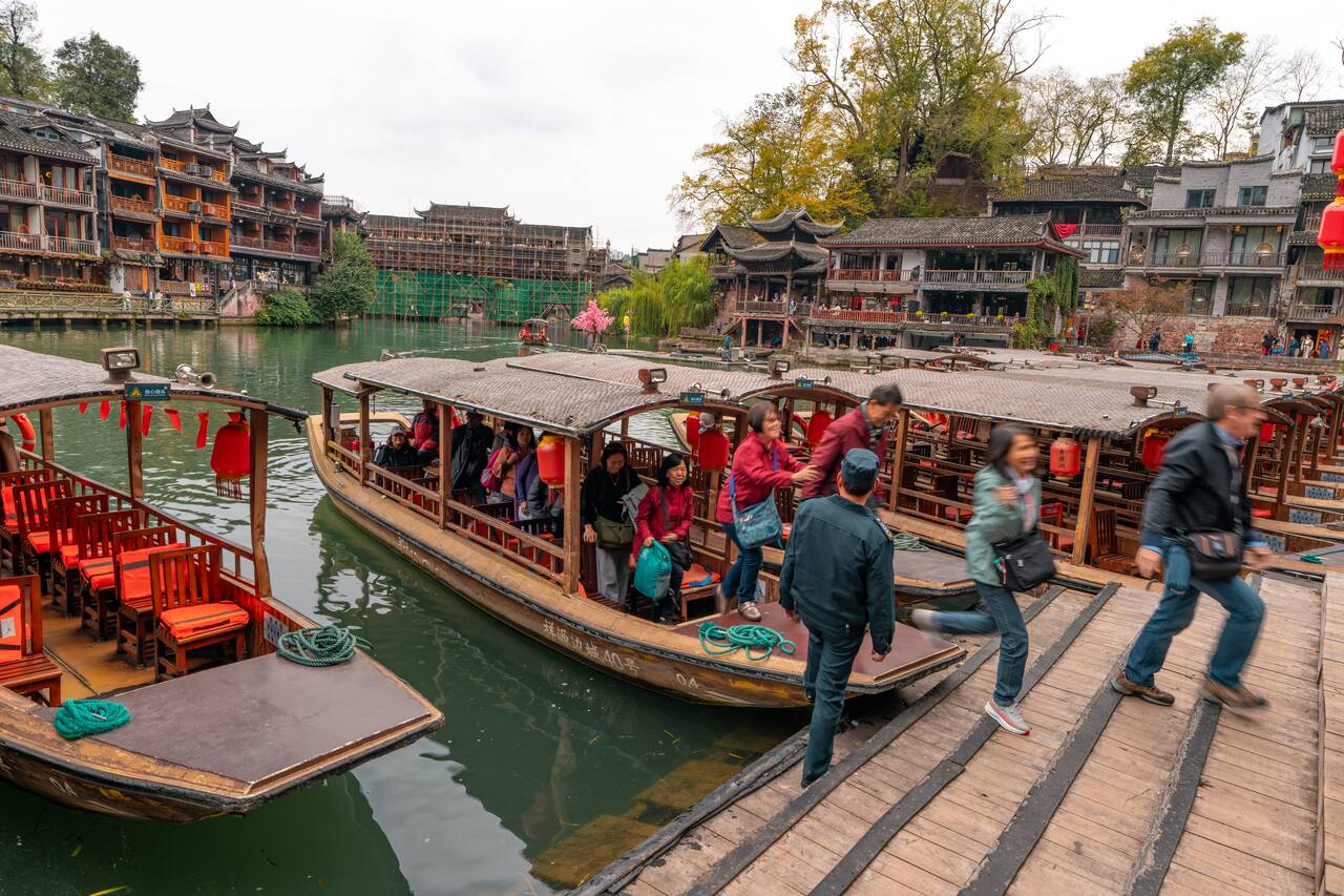 people getting off boats at Fenghuang