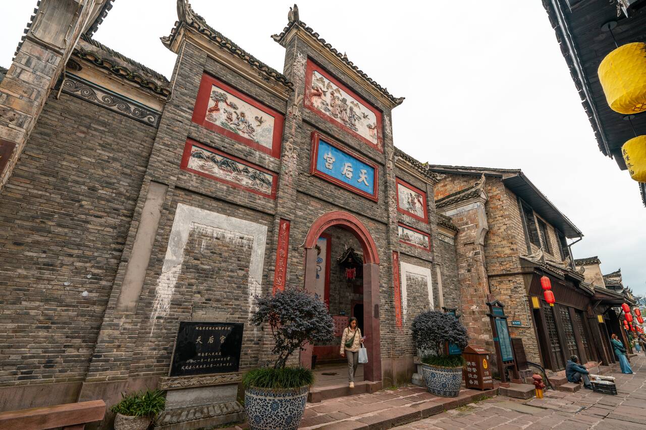 A woman exiting a temple in Fenghuang