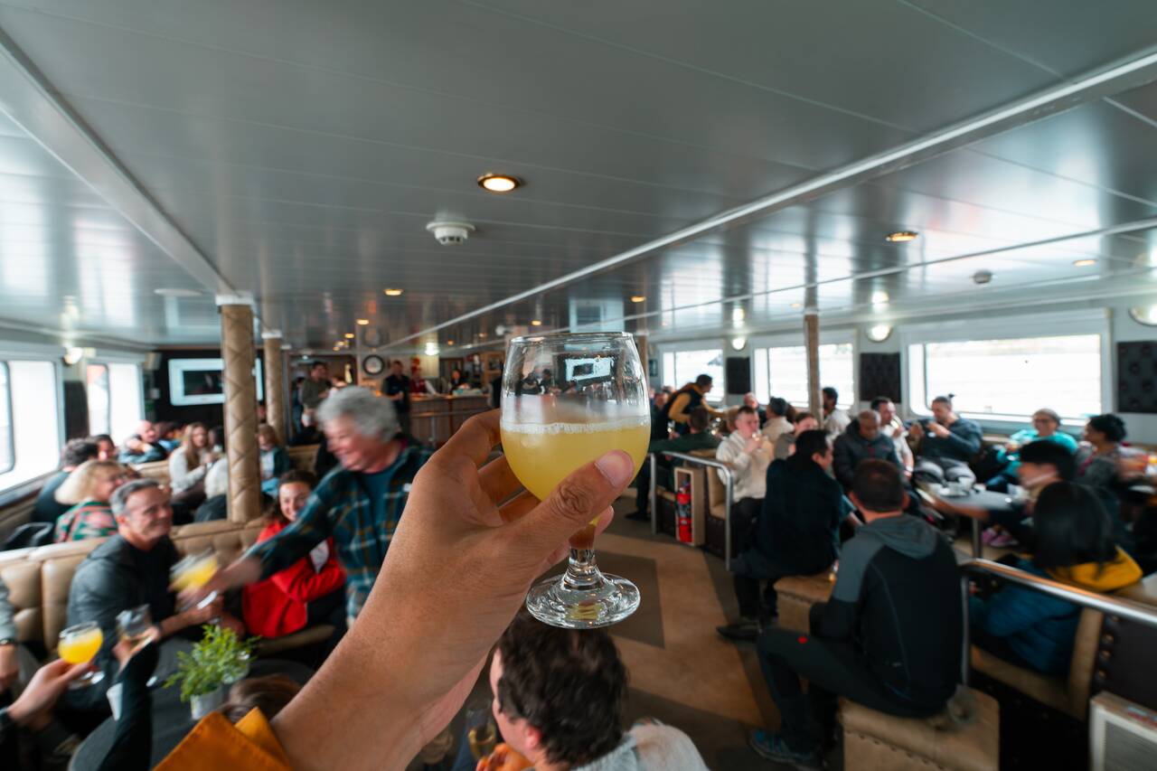 Me holding a glass of drink cheering to the people in the expedition to Antarctica