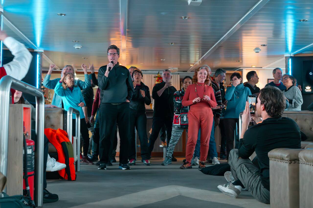 People singing and dancing aboard the ship back from Antarctica