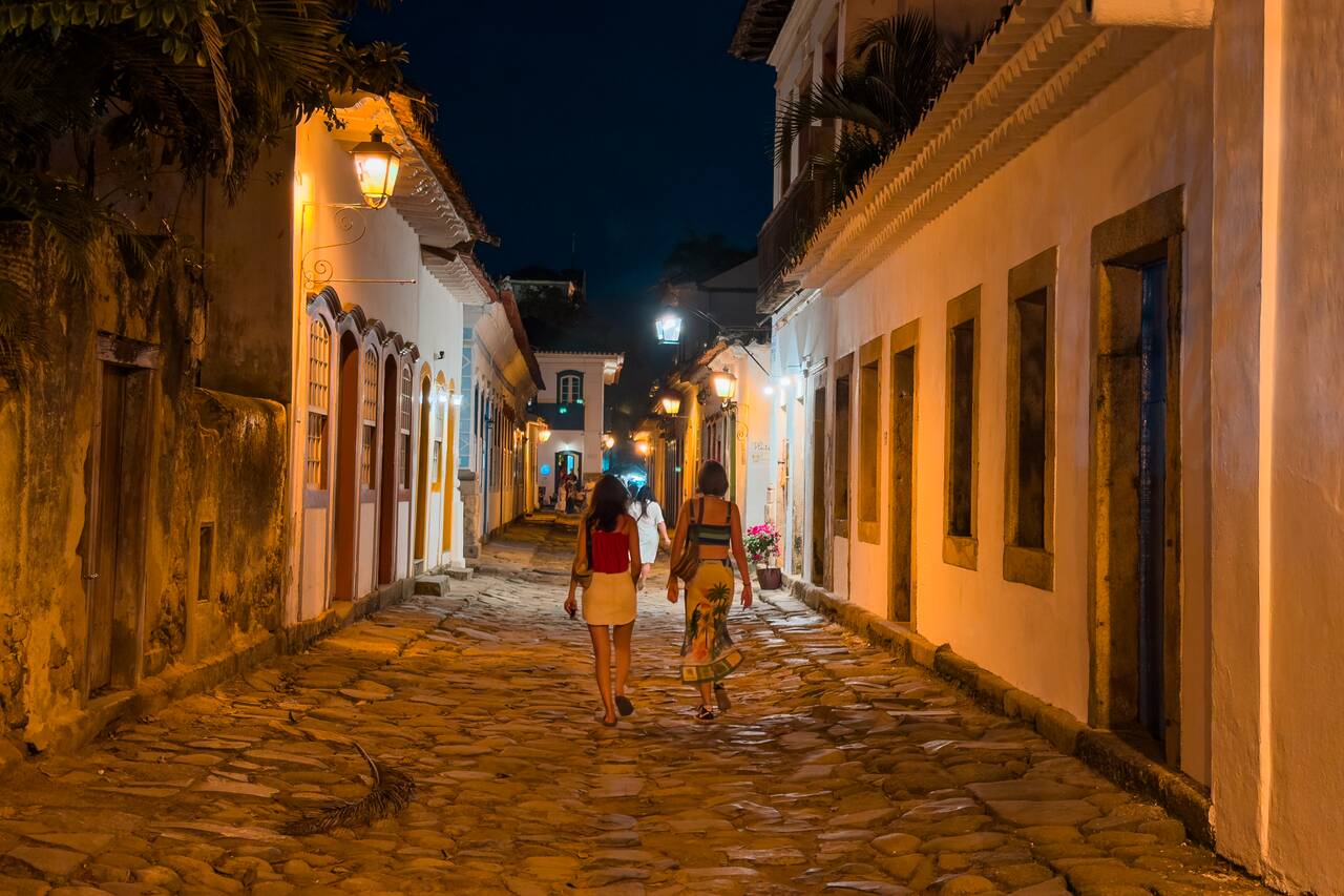 Women walking in the street in Paraty at night