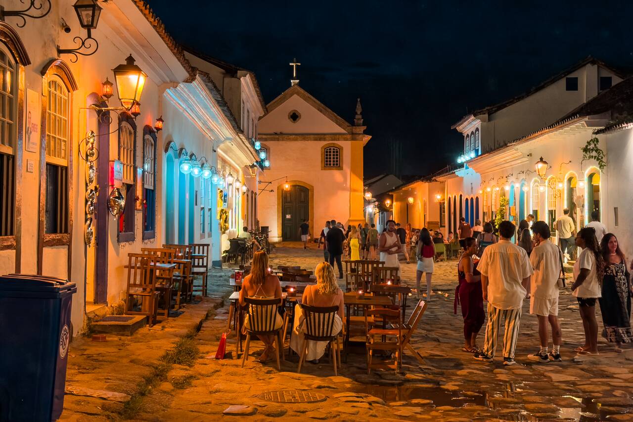 People sitting by the street in Paraty at night