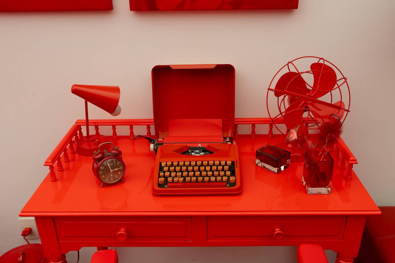 A red desk with red objects at Cildo Meireles Gallery