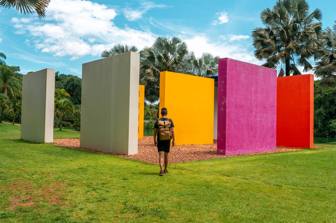 Me walking towards a colrorful art installation in Inhotim