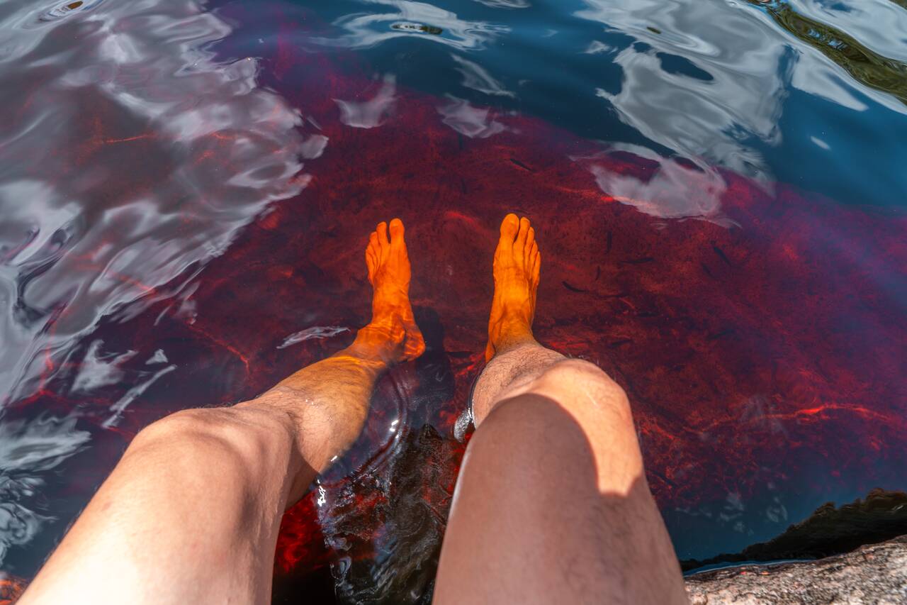 Me feet in the red colored water of Ribeirão do Meio