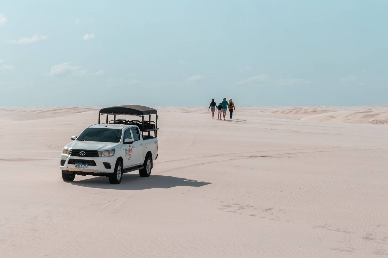 A family walking on the sand dune away from a 4x4 at Lagoa Bonita