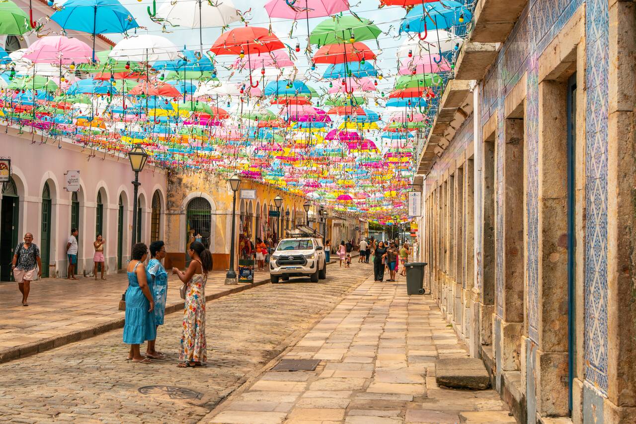 People at a street full of colorful umbrellas in Sao Luis