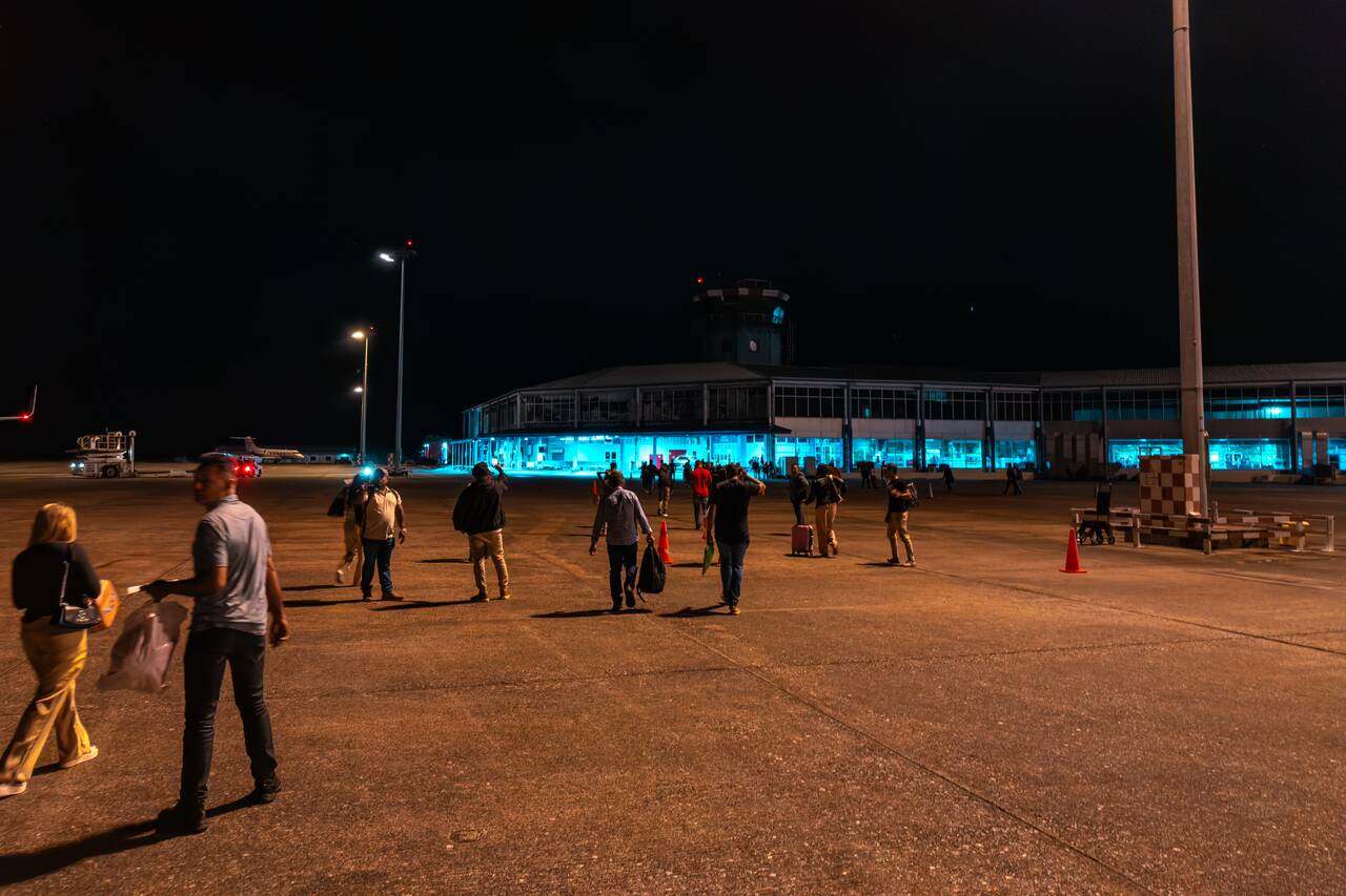 people walking on the tarmac at Suriname international airport