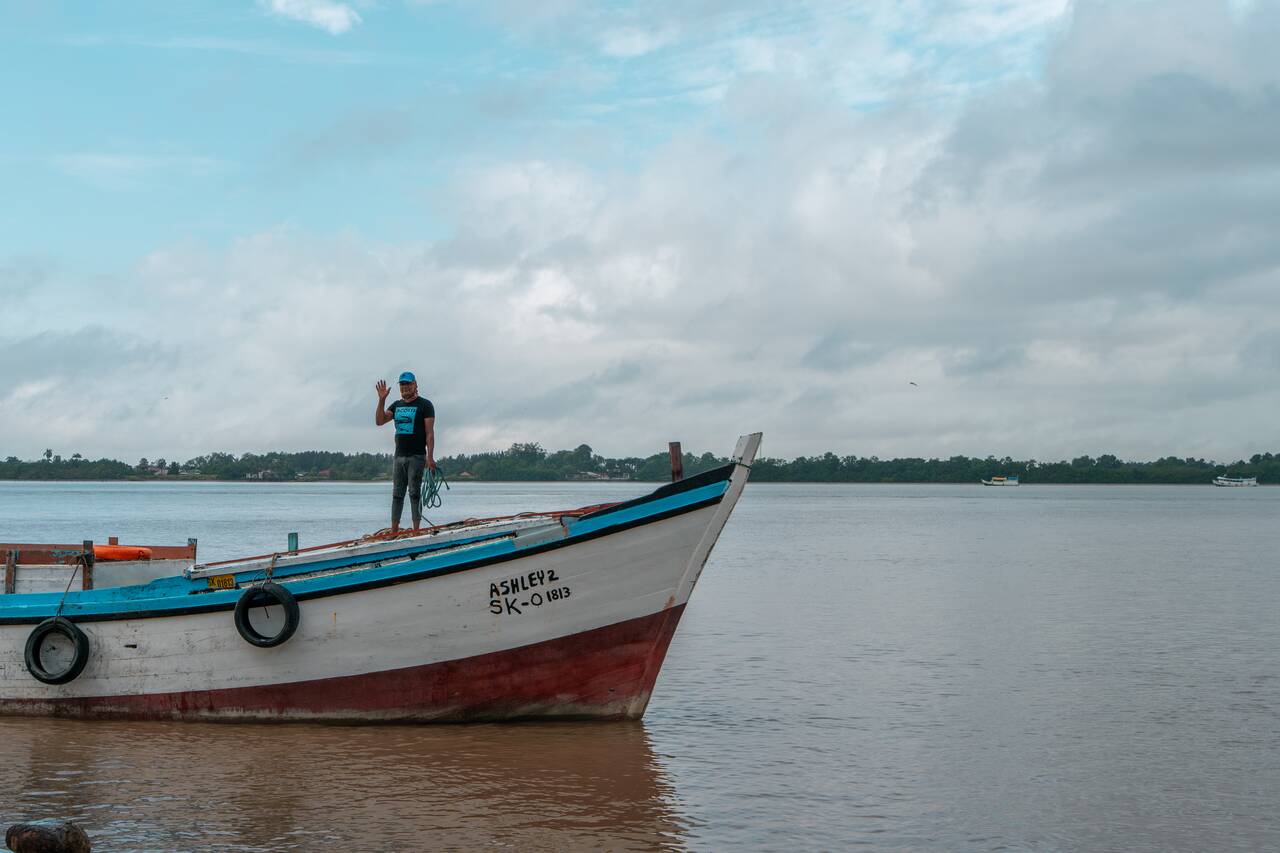 A local on a boat waving at me in Suriname