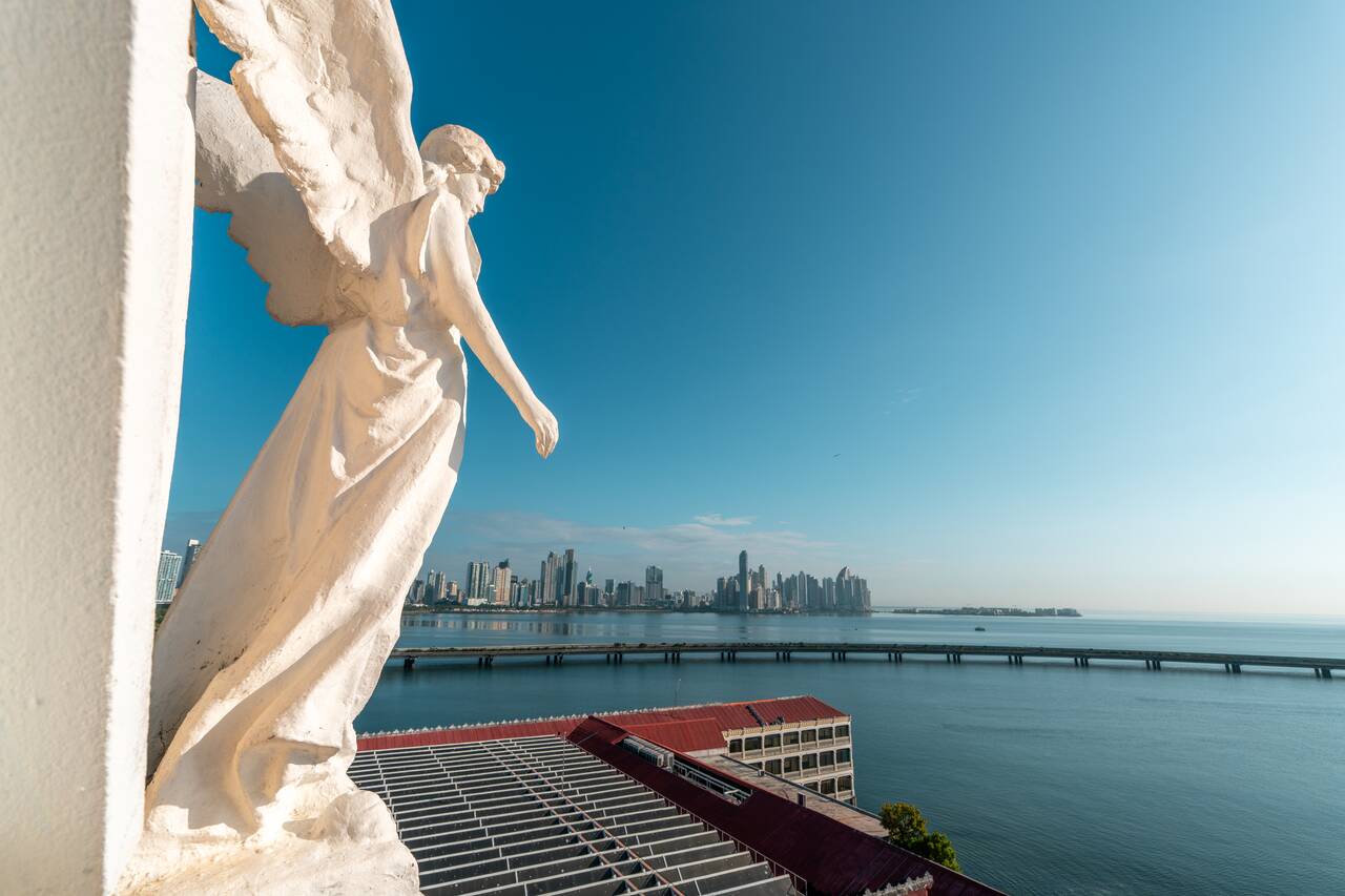 The angel sculpture at the top of San Francisco de Asis Church with the view in the background