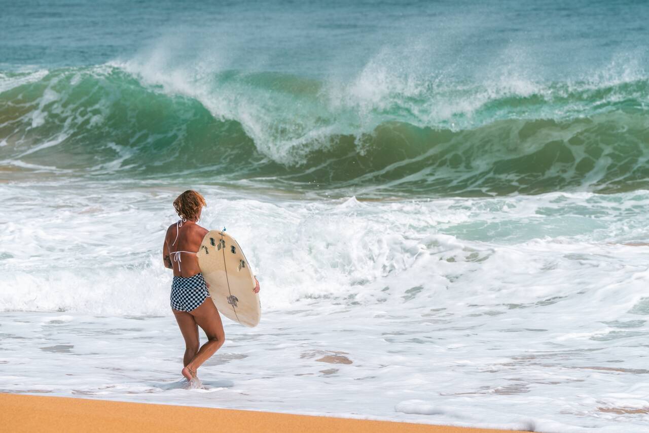 A woman about to go surf at Bluff Beach