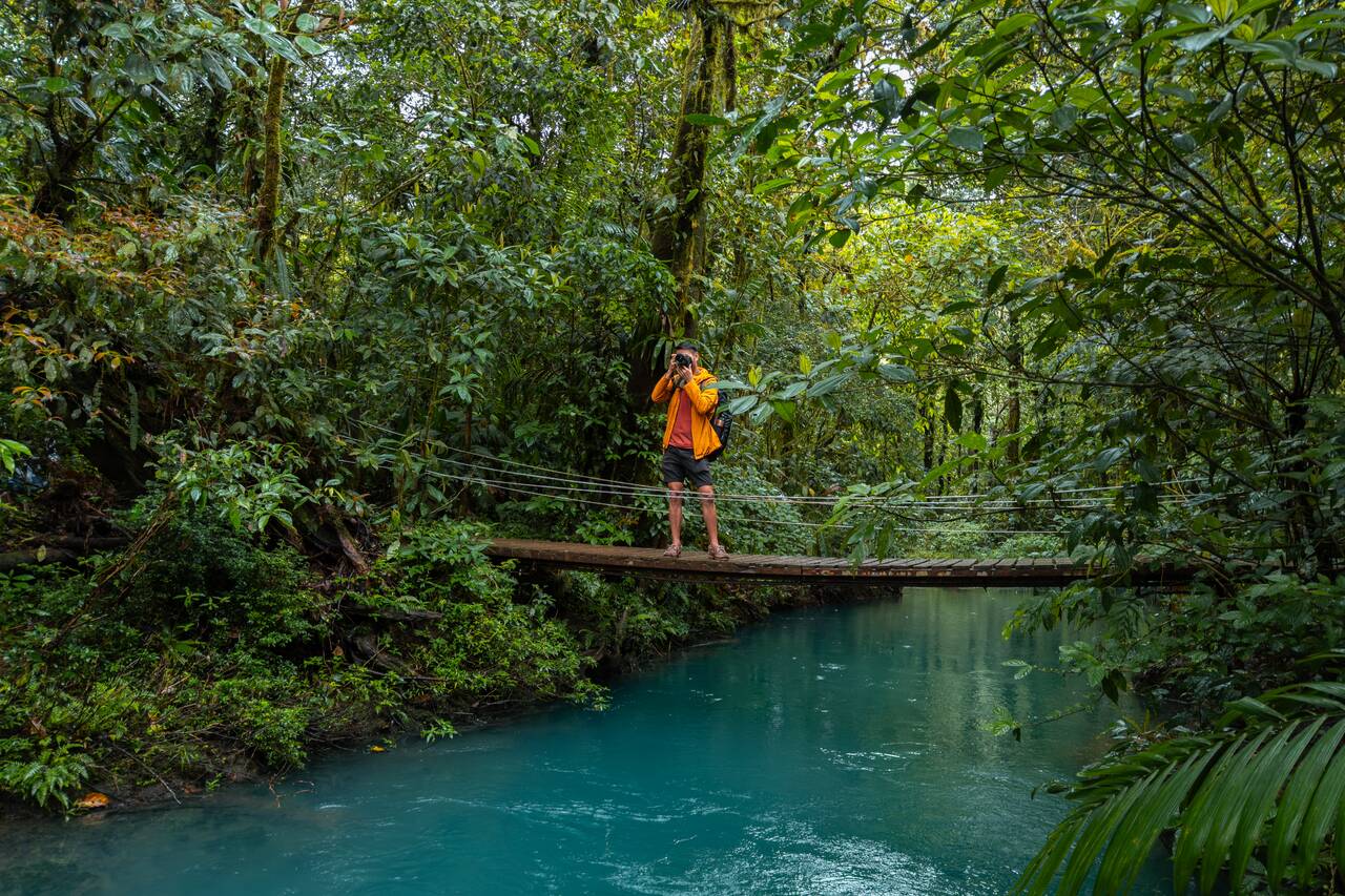 Me taking photos from a suspension bridge along the Rio Celeste trail