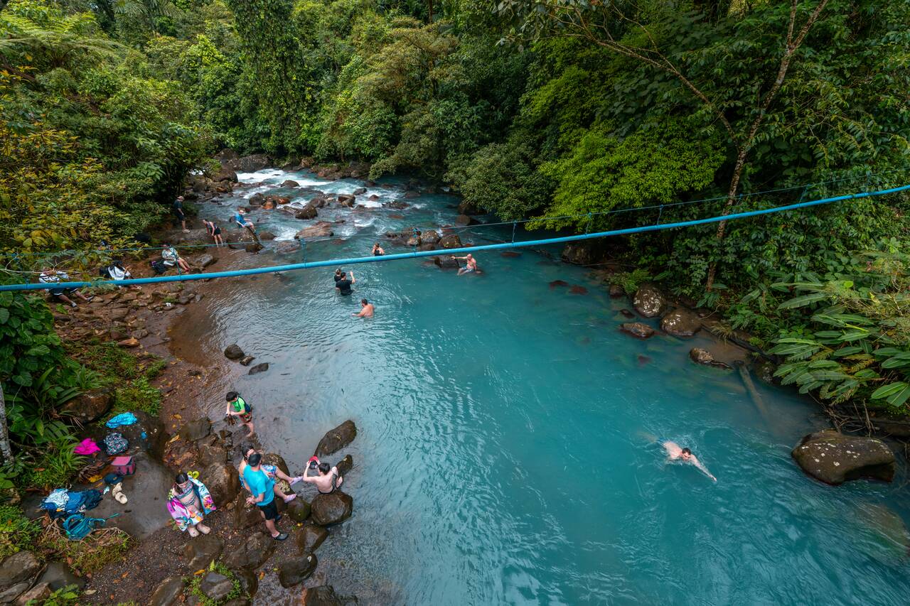 People swimming in Celeste River seen from the bridge