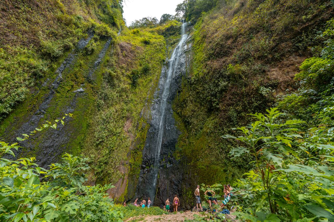 People standing under San Ramón Waterfall