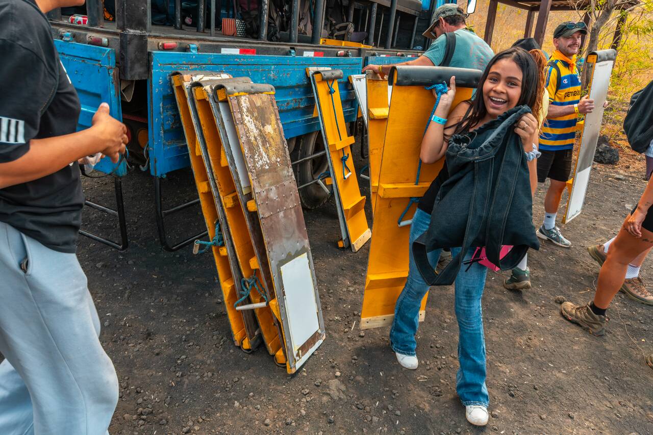 People picking up boards to carry up Cerro Negro