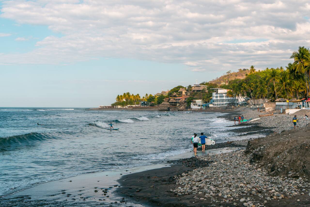 People carryign surfboards in El Tunco