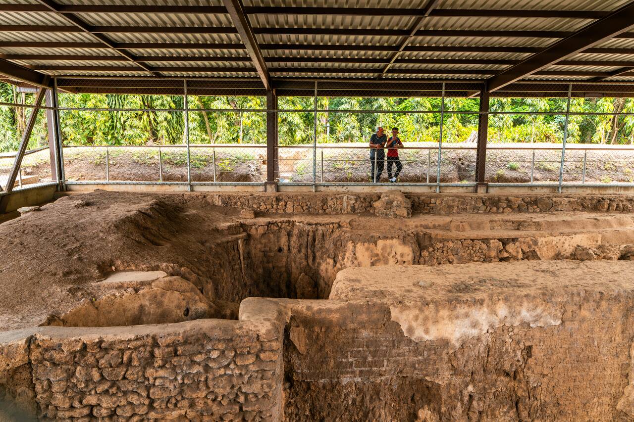 People looking at an excavation site at Tazumal