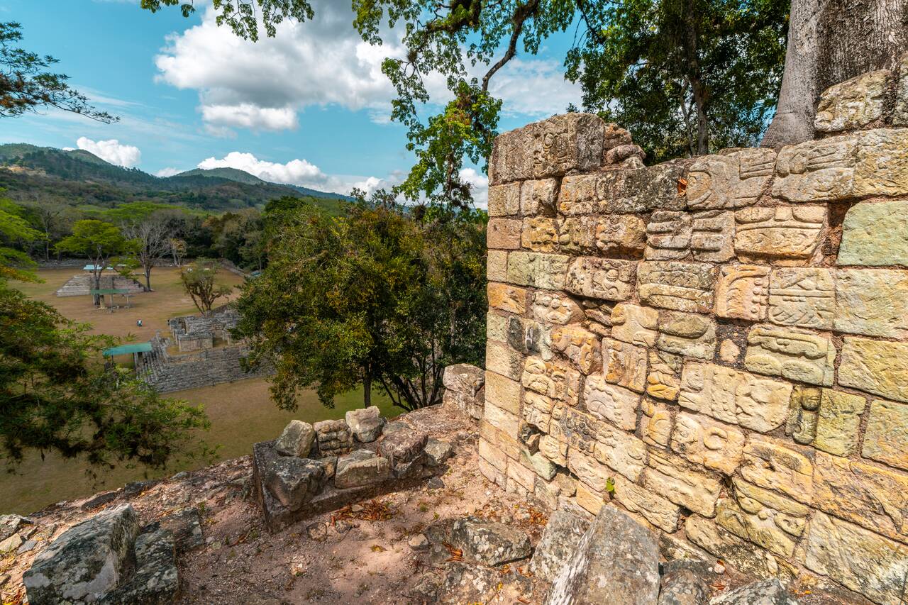 Stone sculptures and the view from a high temple in Copan