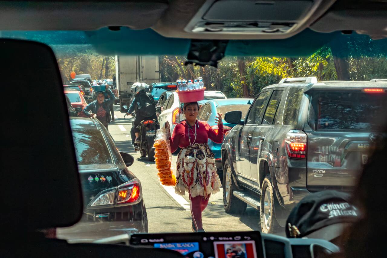 A woman seller selling snacks along a traffic jam road to Antigua