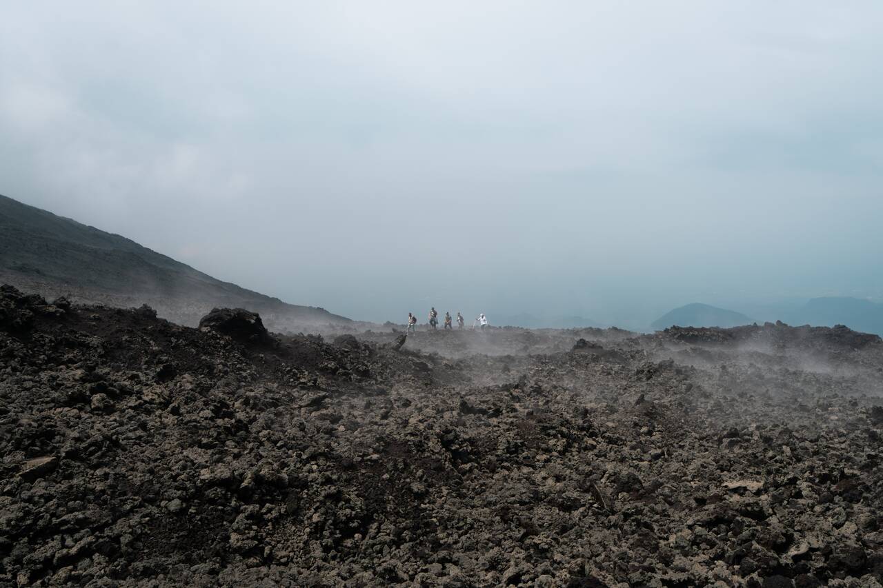 A group of people deep inside the lava field in Pacaya