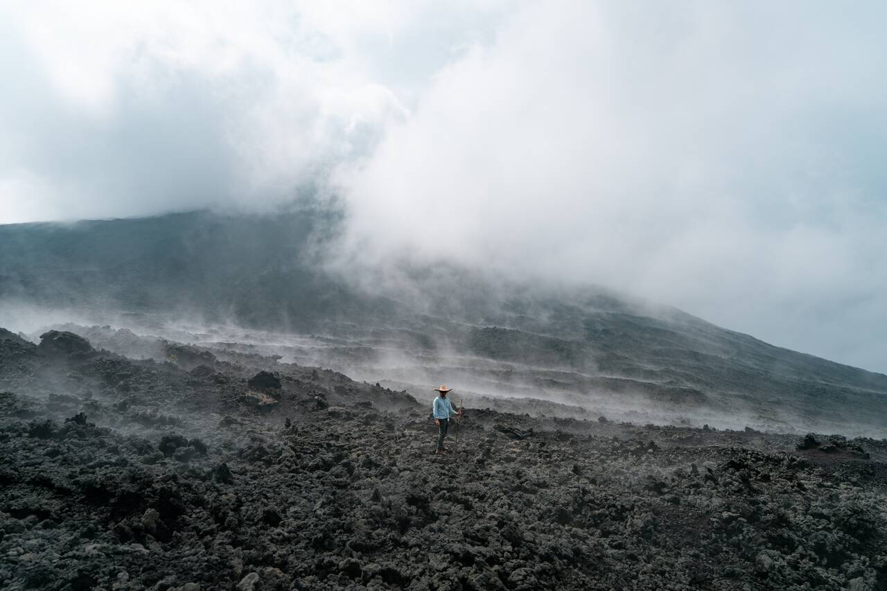 A person on a lava field on Pacaya