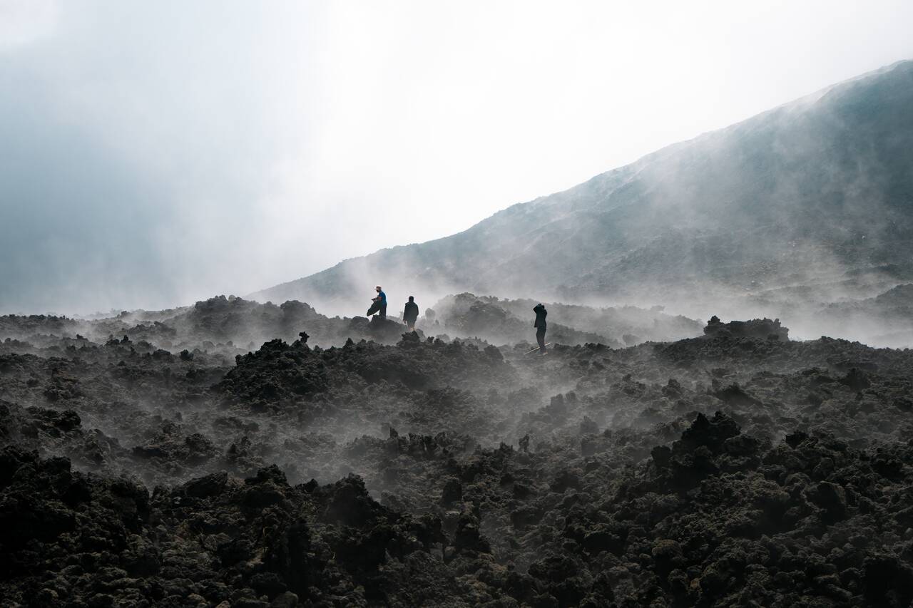 People in the lava field on Pacaya with steam coming out