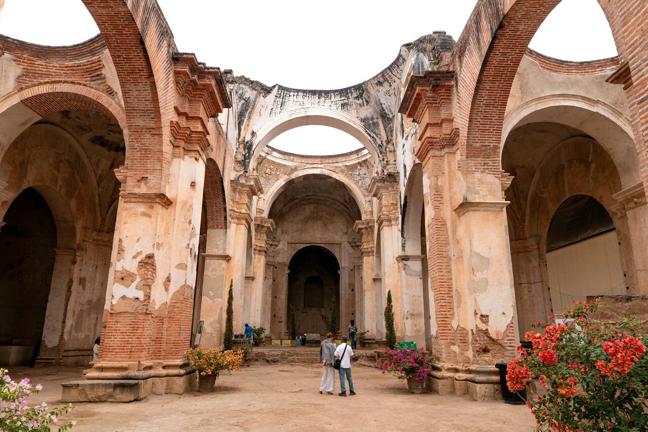 2 people standing in the middle of Antigua Cathedral Ruins