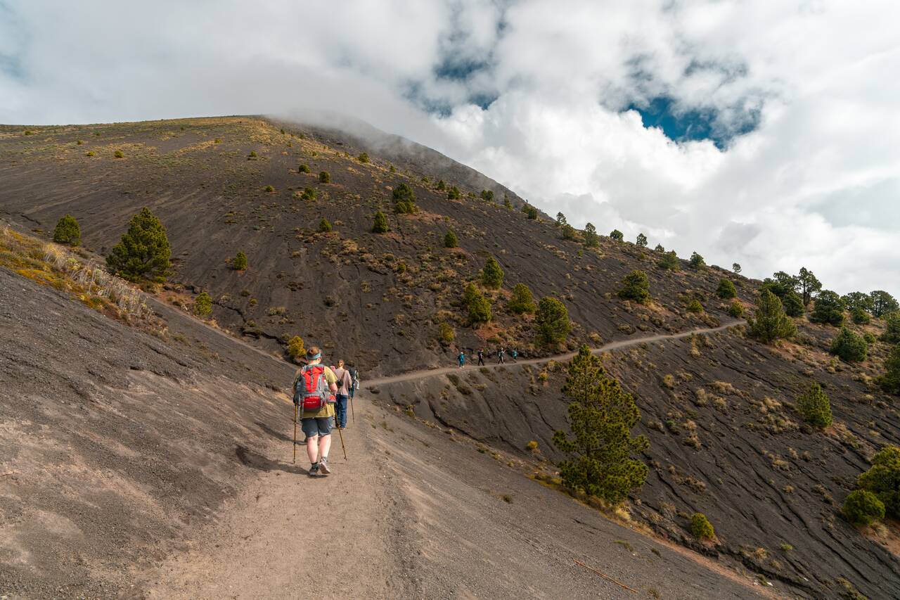 People hiking around the crater to ge to the campsite in Acatenango