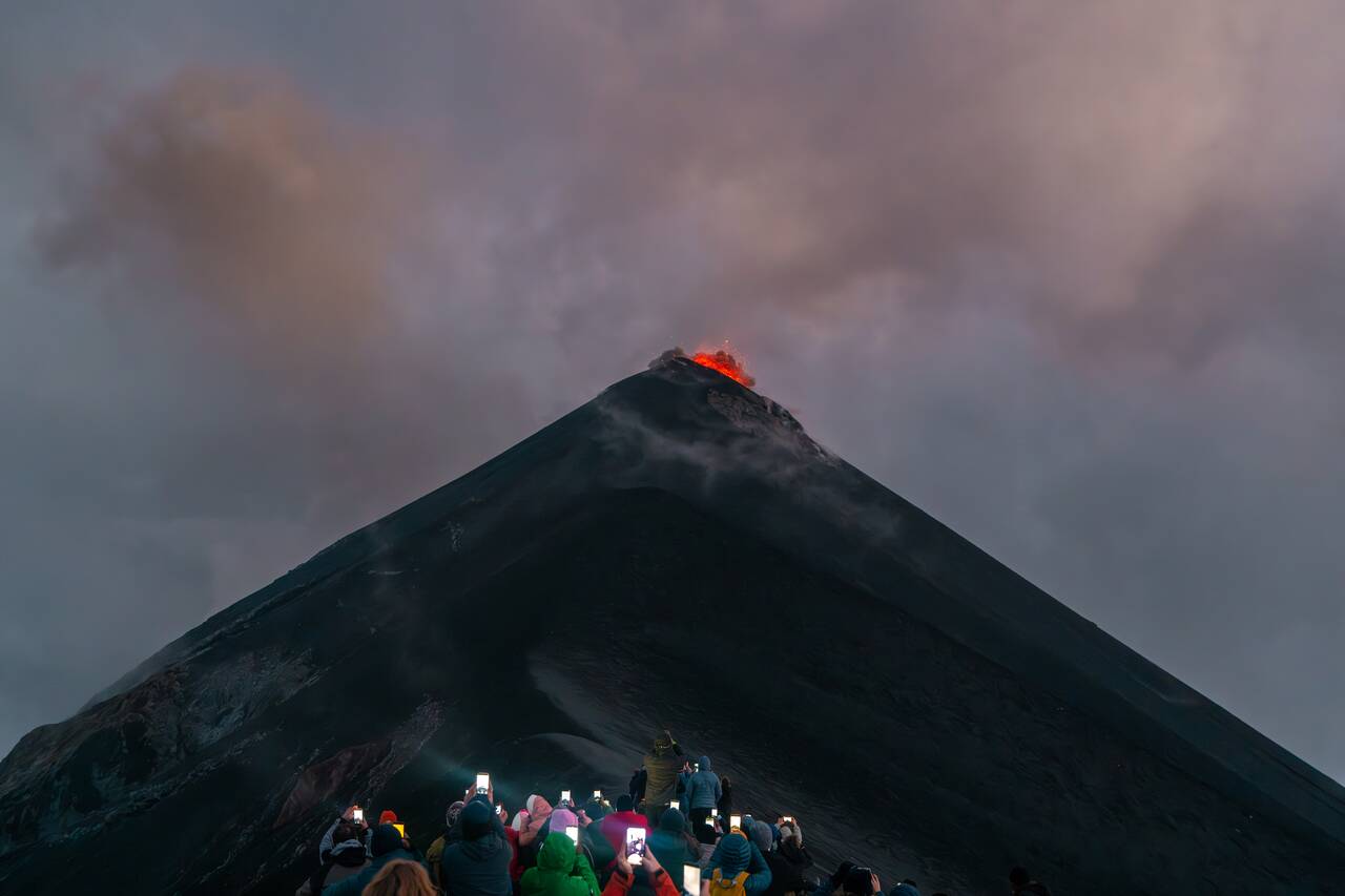 People taking photos of an eruption of Fuego
