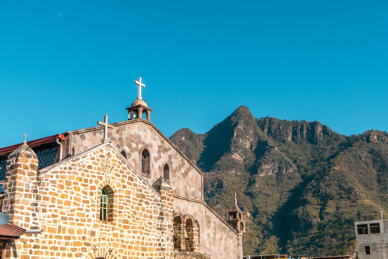 A church with the Indian Nose in the background at San Juan La Laguna
