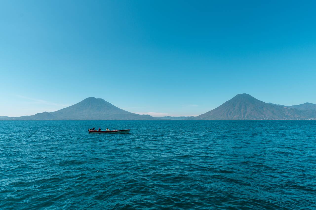 A boat with 2 volcanoes in the backdrop