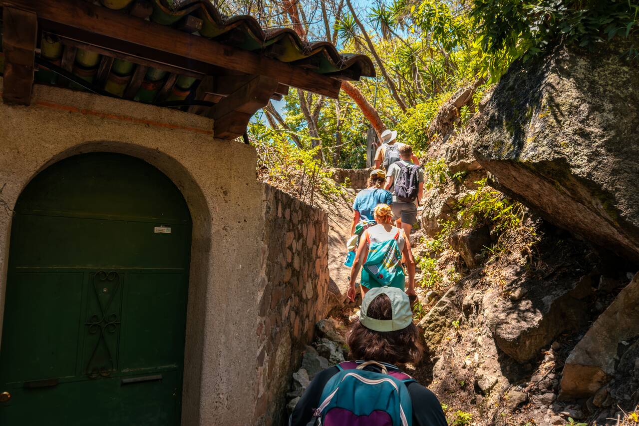 People hiking on a narrow path of the Lower Mayan Trail