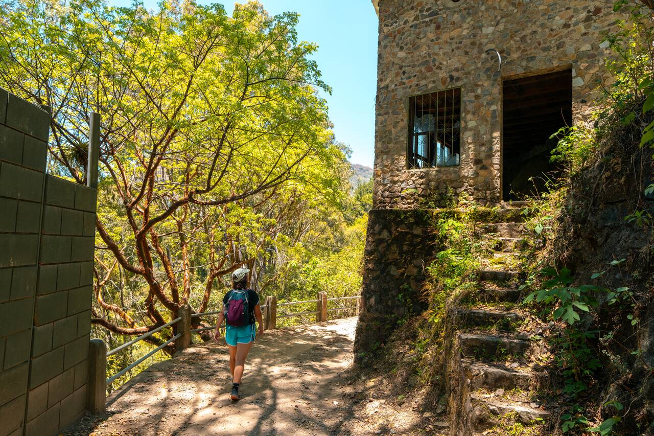 My friend walking passed an abandoned building along the Lower Mayan Trail